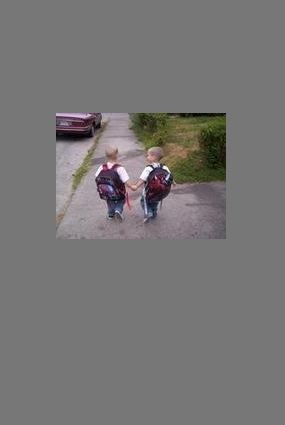 Picture of two children with backpacks holding hands